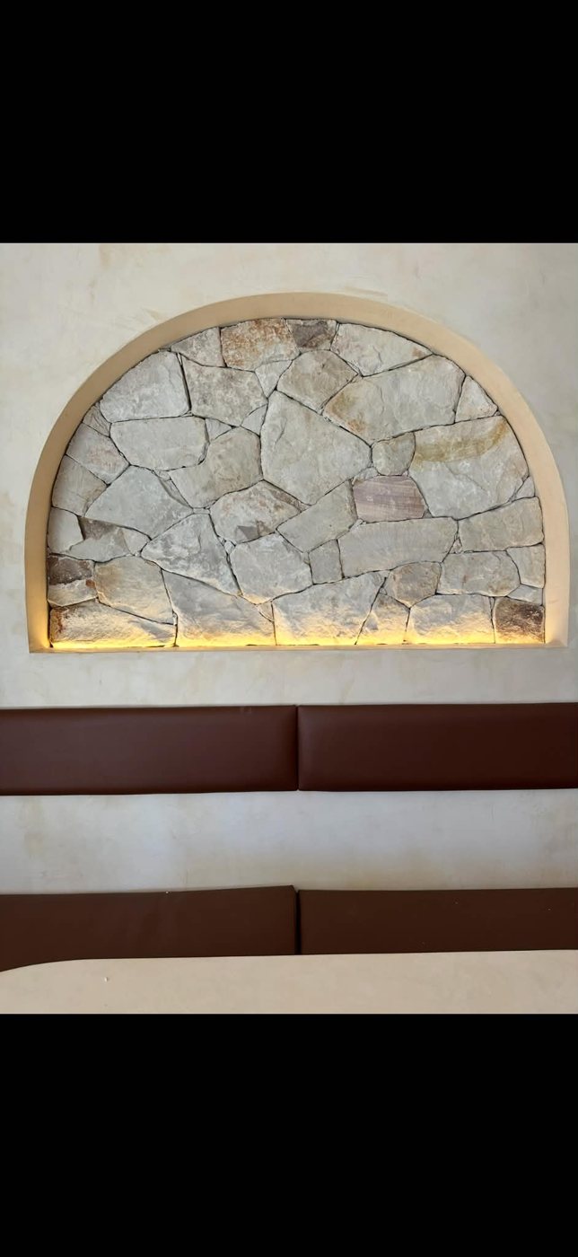 Lit stone feature wall with an arched niche